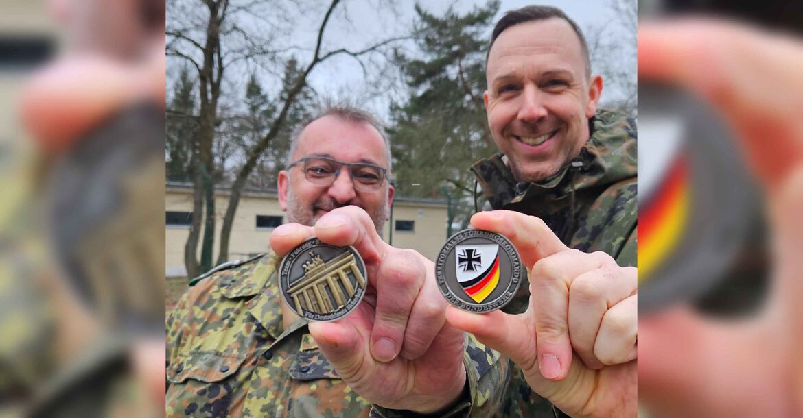 Stabsfeldwebel Jens Hahn (li.) und Hauptfeldwebel Stefan Walczak präsentieren den neuen Coin des Territorialen Führungskommandos der Bundeswehr in Berlin.