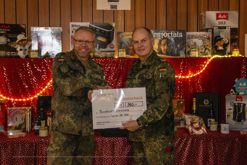 Brigadegeneral Hans-Dieter Müller (re.) übergibt den symbolischen Spendenscheck an den Bereichsvorsitzenden West, Hauptmann Marcus Sigge.