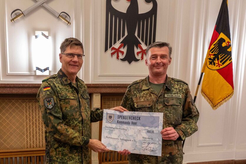 Generalmajor Peter Mirow (li.), Chef des Stabes Kommando Heer, überreicht dem Bereichsgeschäftsführer Ost, Hauptmann Steffen Knoblauch, den symbolischen Spendenscheck über 650 Euro.
