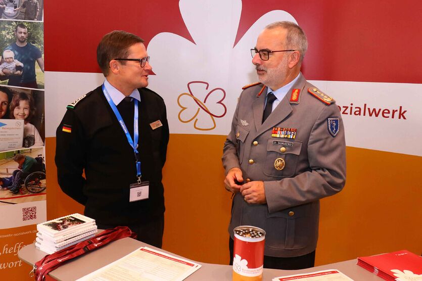 Generaloberstabsarzt Dr. med. Ulrich Baumgärtner, Inspekteur des Sanitätsdienstes, informiert sich bei Oberstabsfeldwebel Mario Borutta (li.) über das Bundeswehr-Sozialwerk. 