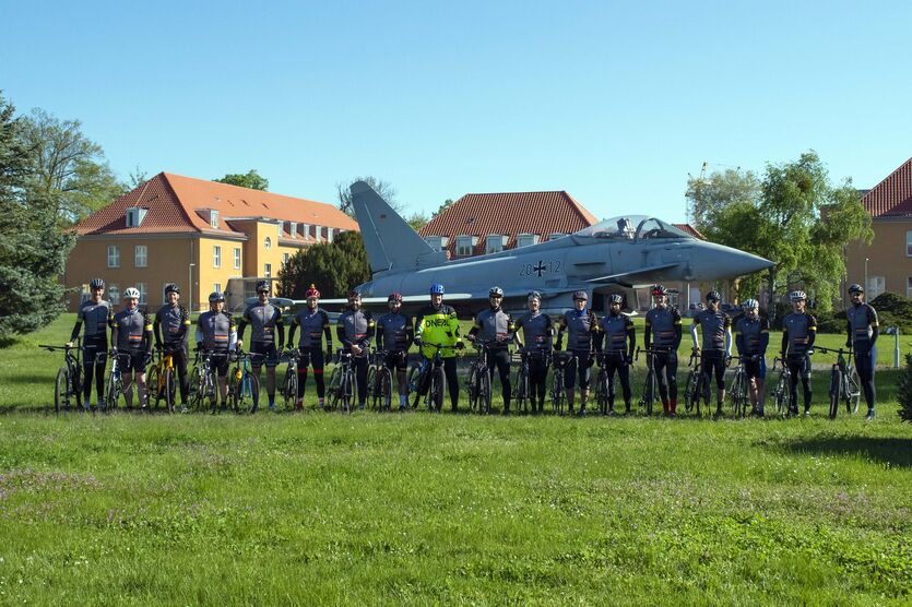 Das Radsportteam vor einem Eurofighter in der General-Steinhoff-Kaserne in Berlin-Gatow
