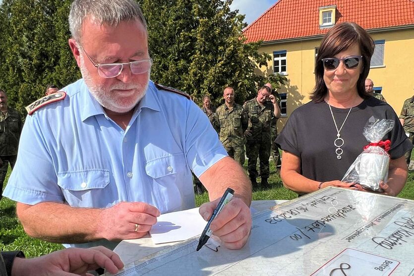 Oberstabsfeldwebel Jörg Kücking unterschreibt den symbolischen Spendenscheck.