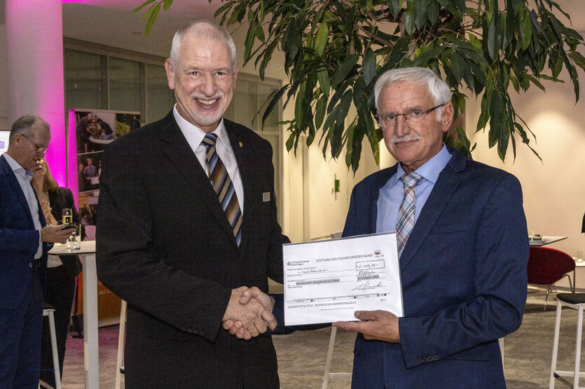 Oberst a.D. Helmut Kolb (re.) überreicht einen symbolischen Spendenscheck des „Deutschen Offizier Bund“ über 2.000 Euro an Uwe Sander.