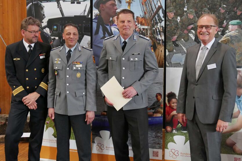 Bereichsvorsitzender (li. außen) und Bundesvorsitzender (re. außen) zeichnen OStFw Ingo Evers und OberstLt Lutz Arnoldt (v.li.) mit der Ehrennadel in Silber aus. 