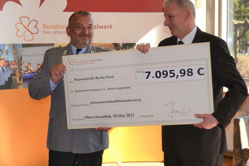 Der „Mann der 1.000 Ideen“, Stabsfeldwebel Jens Hahn, überreicht Bereichsvorsitzenden Frank Siedow seinen symbolischen Spendenscheck. 