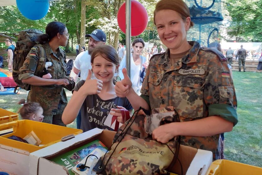 Major Jana Grigoleit mit Tochter stöbern am Info-Stand des BwSW. 