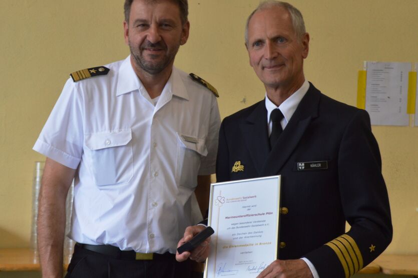 Kapitän zS Matthias Kähler (re.) nahm für die Marineunteroffizierschule die Ehrenmedaille in Bronze von Stabskapitänleutnant Hermann Kaufhold entgegen.