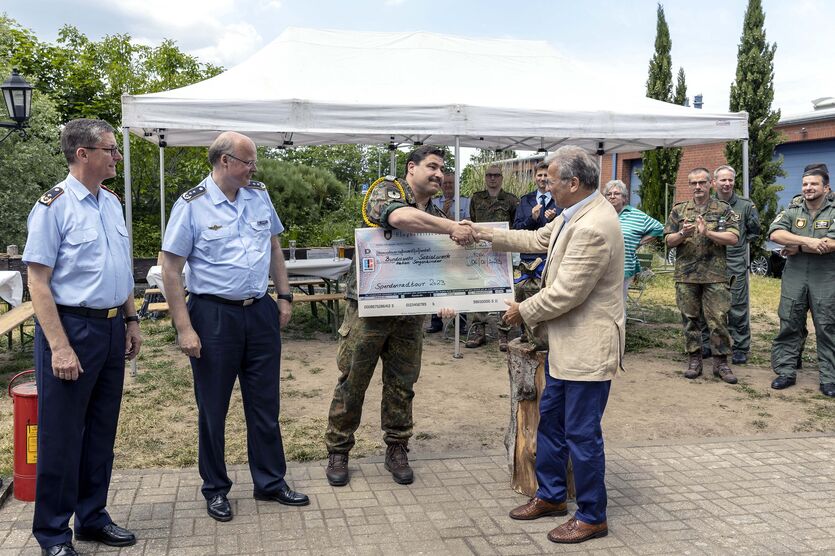Der Höhepunkt: Cheforganisator Oberstabsfeldwebel Hans Holzmann übergibt den symbolischen Spendenscheck über 29.500 Euro an den Bundesvorsitzenden des BwSW, Bernd Krämer. 