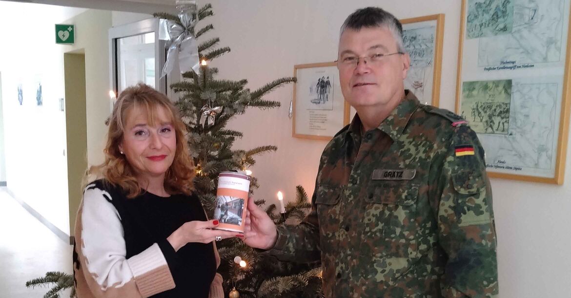 Oberstleutnant Heiko Grätz überreicht sein  „Geburtstagsgeschenk“ in der Spendendose an Regierungshauptsekretärin Anja Sinzig von der Regionalstellenleitung des BwSW.