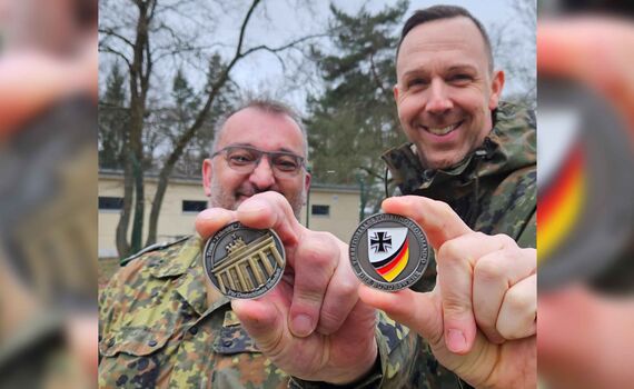 Stabsfeldwebel Jens Hahn (li.) und Hauptfeldwebel Stefan Walczak präsentieren den neuen Coin des Territorialen Führungskommandos der Bundeswehr in Berlin.