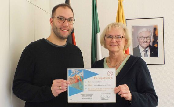 Freudige Überraschung für den Mitarbeiter des BwDLZ: Sonja Reinermann überreicht ihm den Reisegutschein des BwSW. 